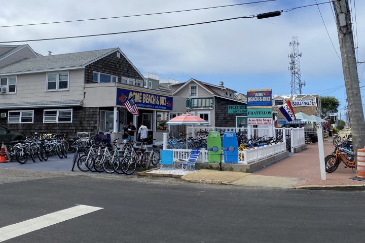 Bicycle shop with bikes displayed outside on a cloudy day.