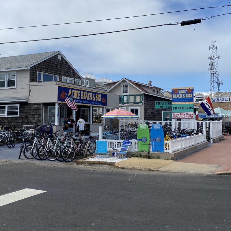 Bicycle shop with bikes displayed outside on a cloudy day.